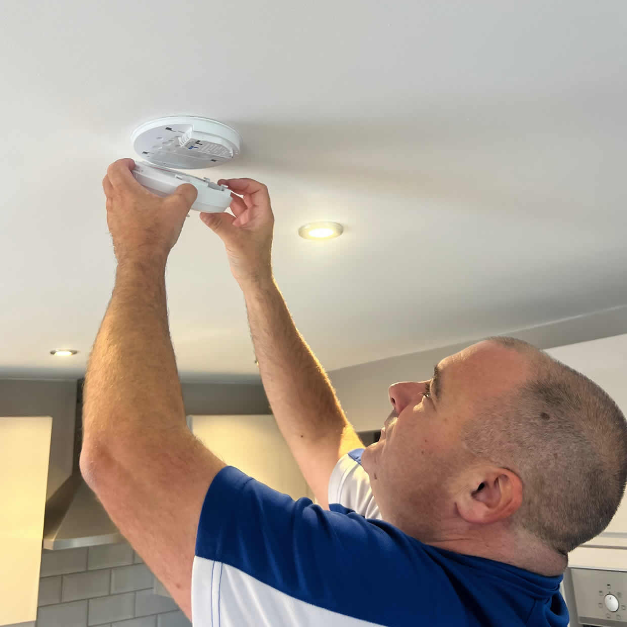 Smoke alarm installer fitting an alarm in a Jarrow property